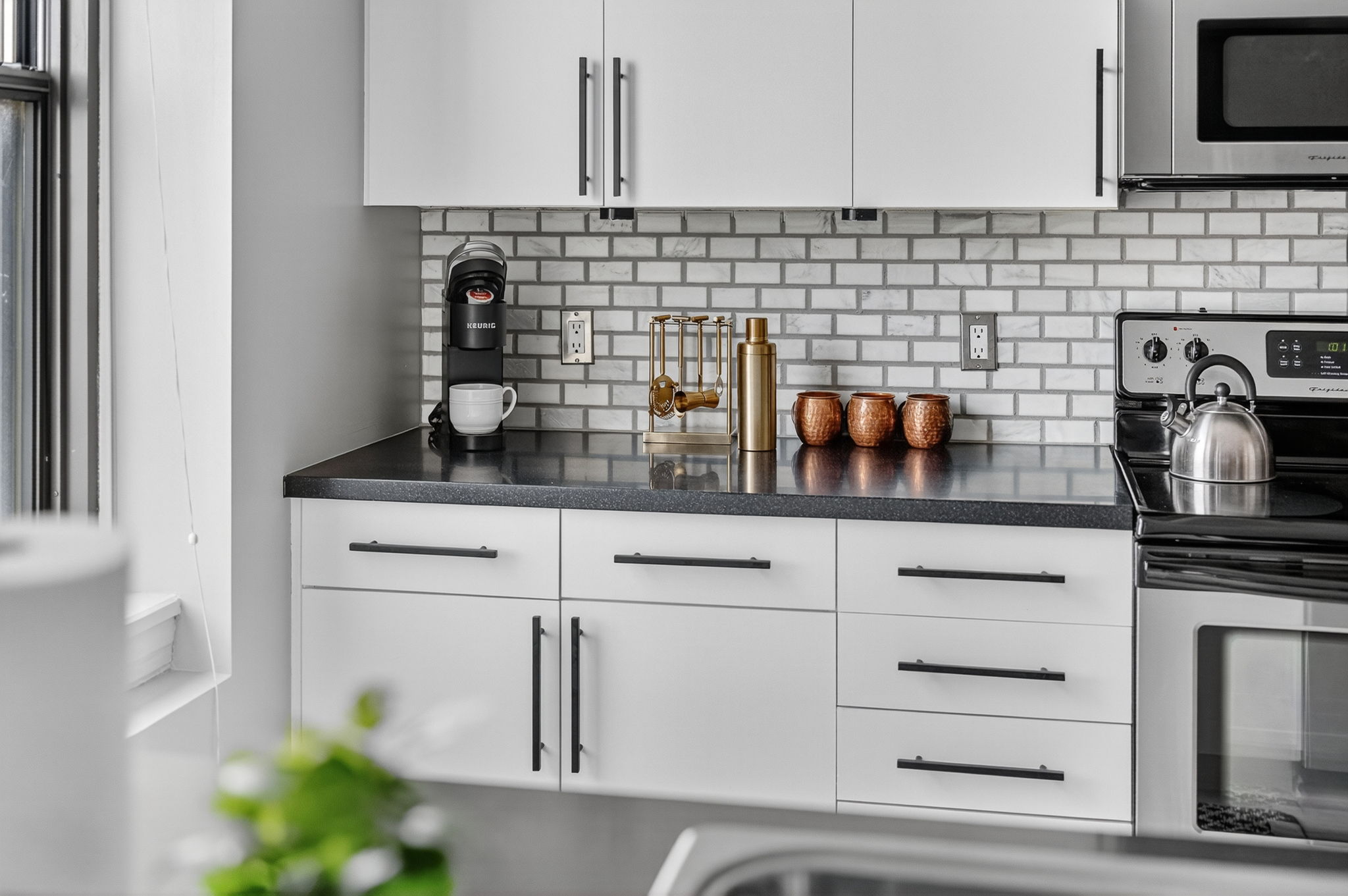 Sleek and functional—your modern kitchen comes stocked with essentials, including a Keurig, barware, and plenty of prep space for takeout or home-cooked meals.