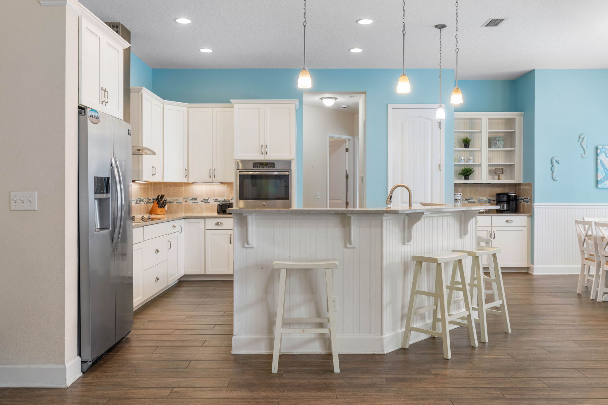 Start the morning with coffee at the island, swap beach plans over breakfast, and come back hungry for fresh seafood and late-night laughter—this bright coastal kitchen keeps everyone together from first light to last bite.