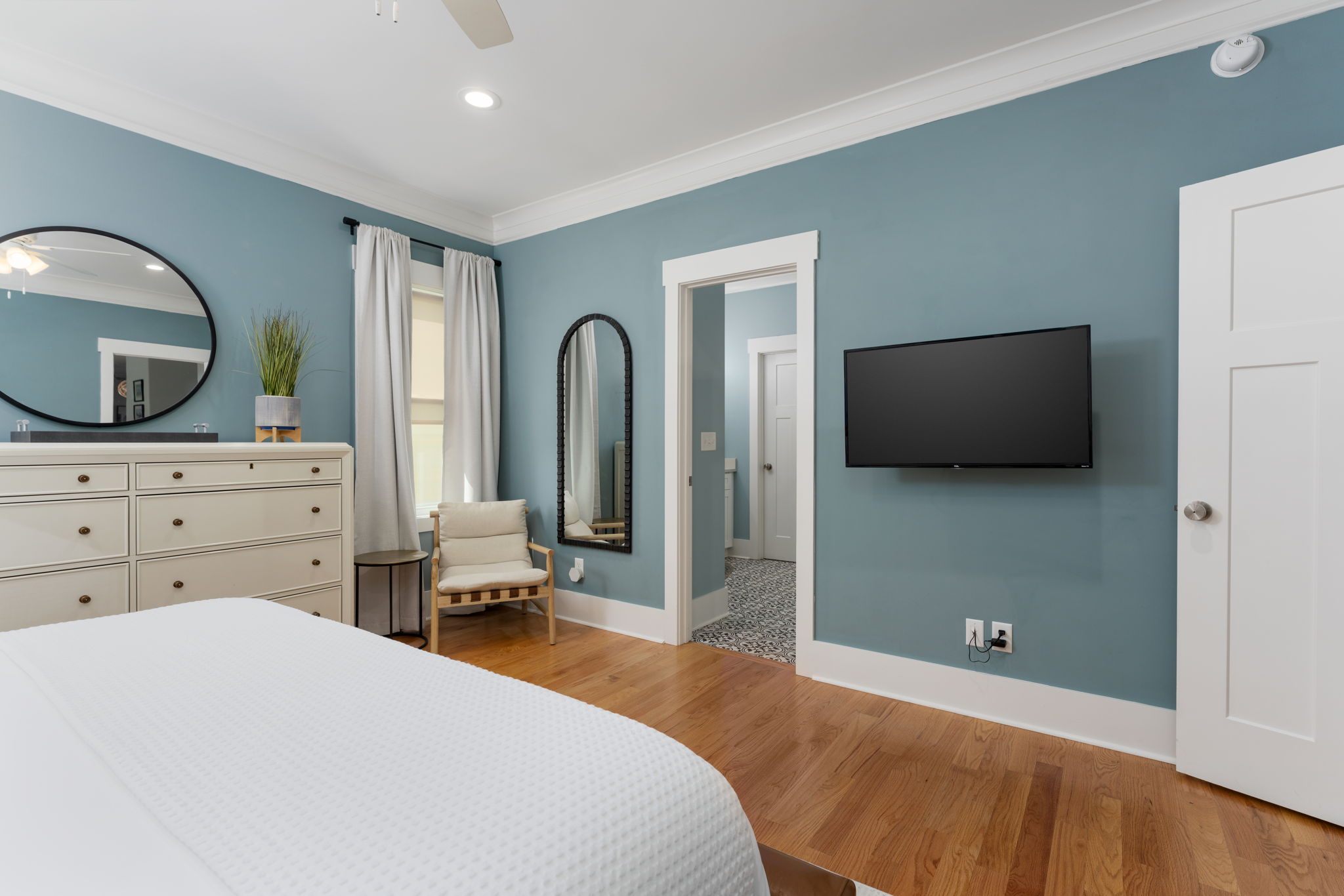 Primary suite with wall-mounted TV and easy access to the en suite bathroom.