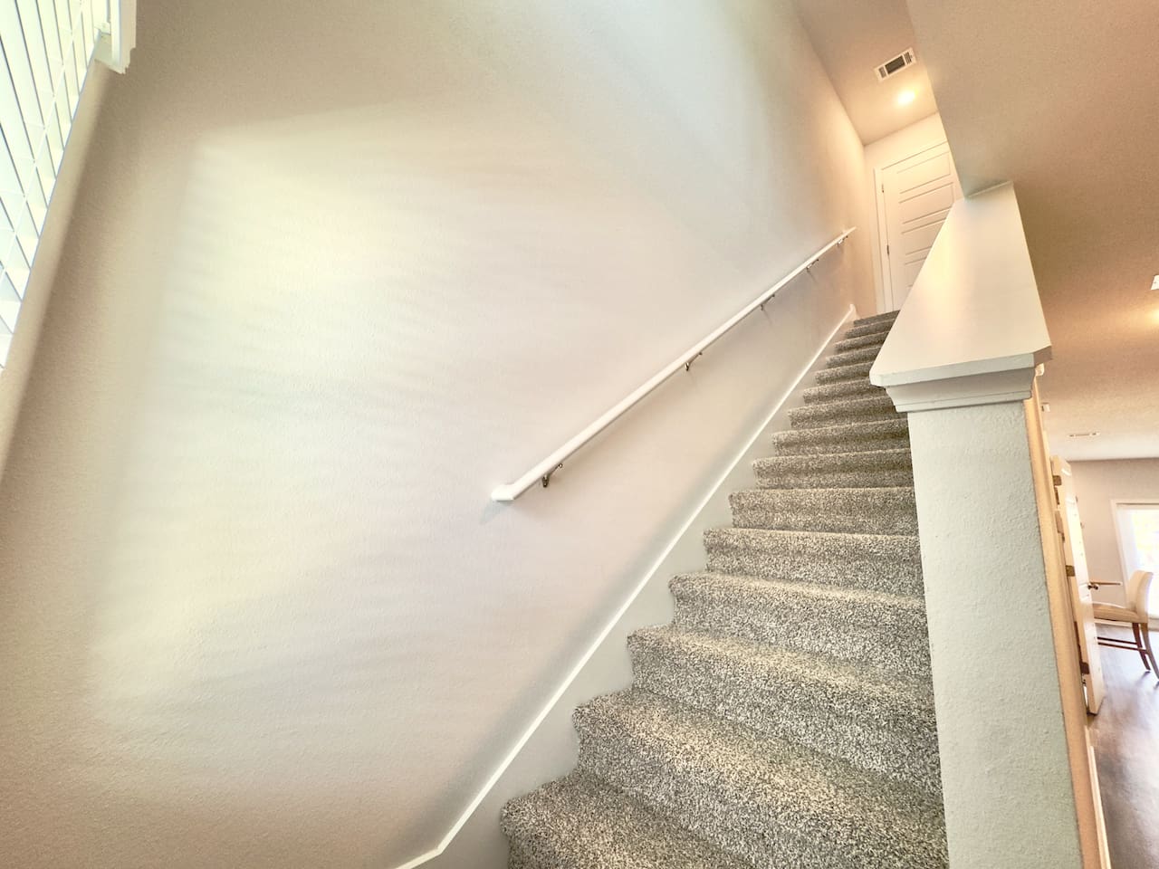 Handrail smooth under your palm, carpeted steps soft and sturdy. Easy climb, quiet, leading you up to the bedrooms.