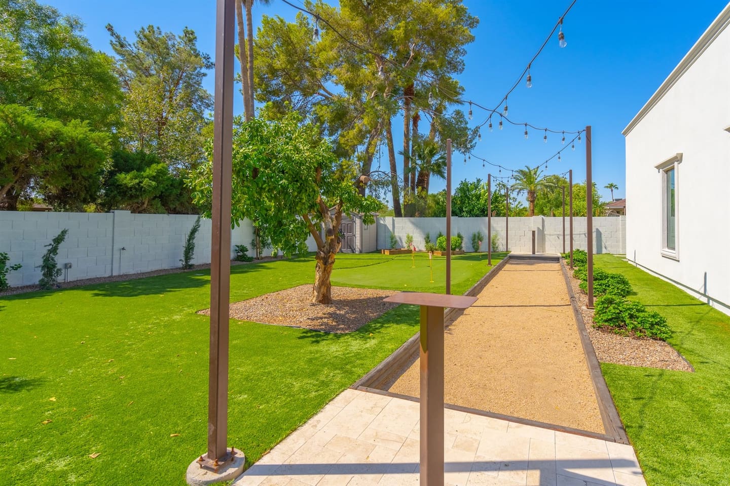 Charming outdoor walkway beside a mini golf area, ideal for a backyard celebration or intimate wedding. Create lasting memories in this serene and picturesque space!