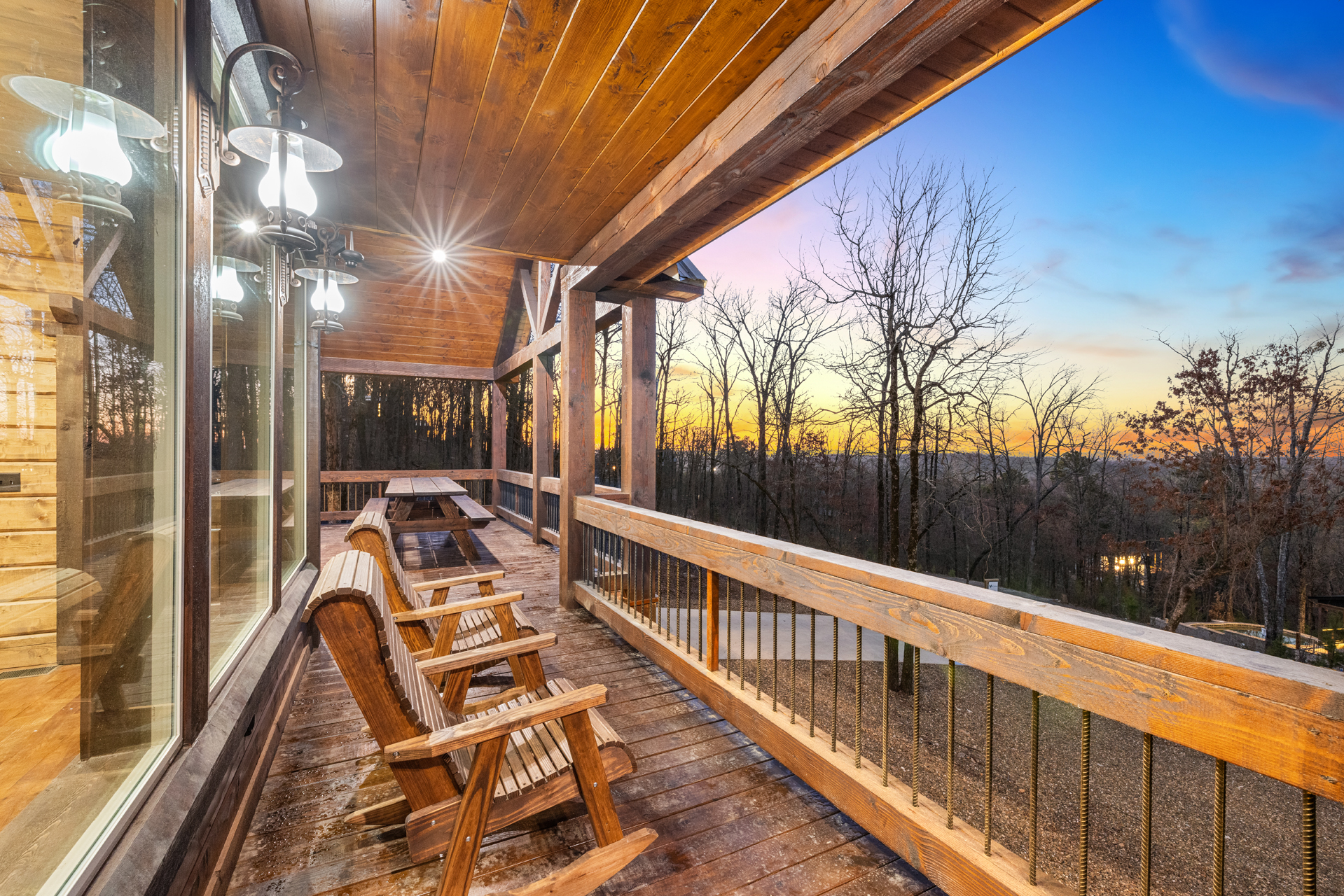 Covered wraparound porch with rocking chairs and beautiful sunset scenery