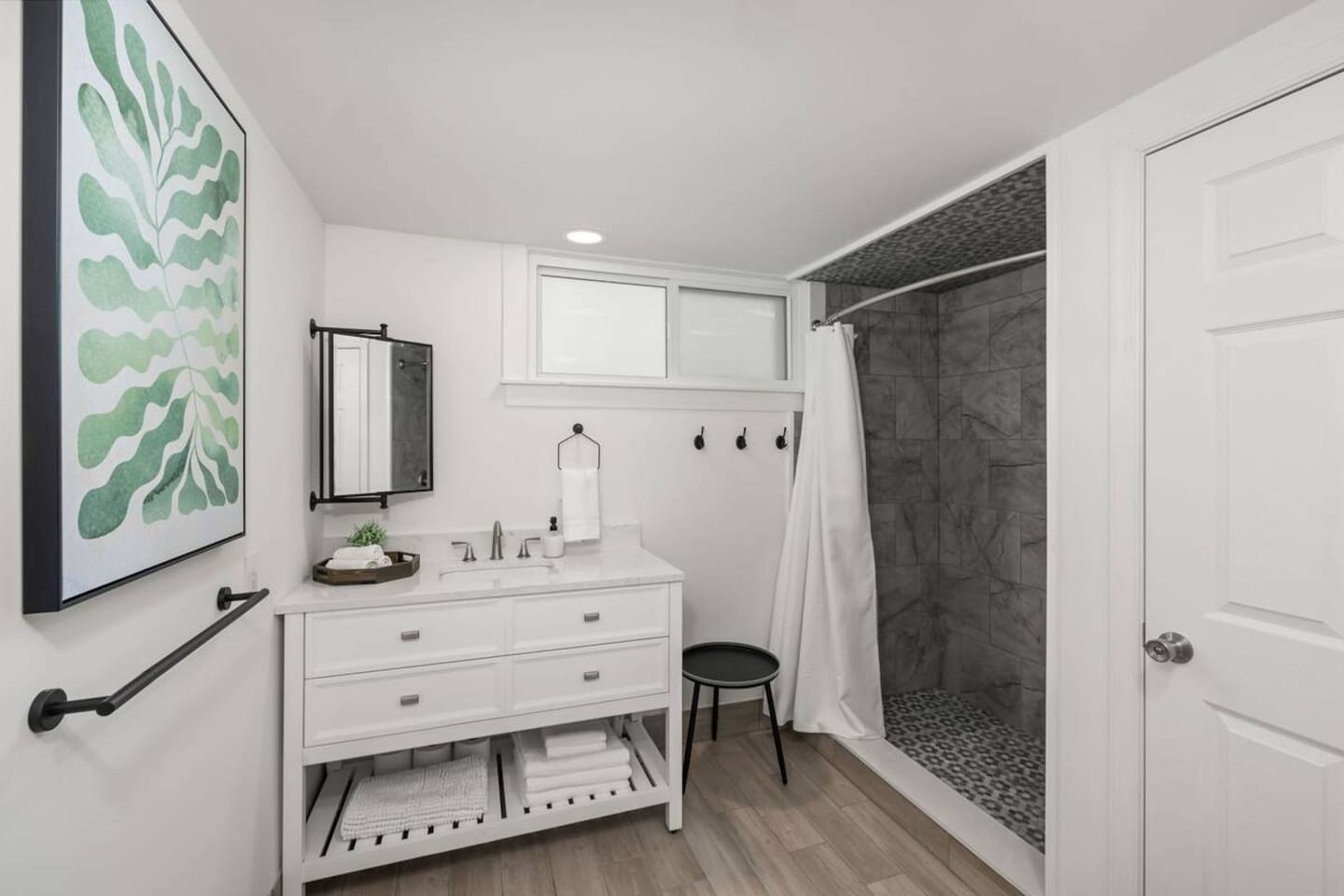 Bathroom includes toilet, vanity with sink, and tile shower.