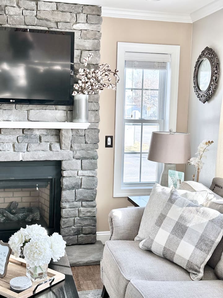 Cozy up in this inviting armchair right next to the beautiful stone fireplace. With soft pillows and plenty of natural light, it’s a perfect little corner for guests to settle in with a good book or enjoy the warmth of the fire.