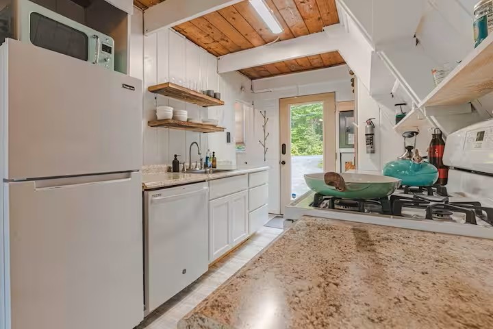 The kitchen complete with four-burner gas stove, dish and glassware, and all the cookware items you'll need to make your meals.