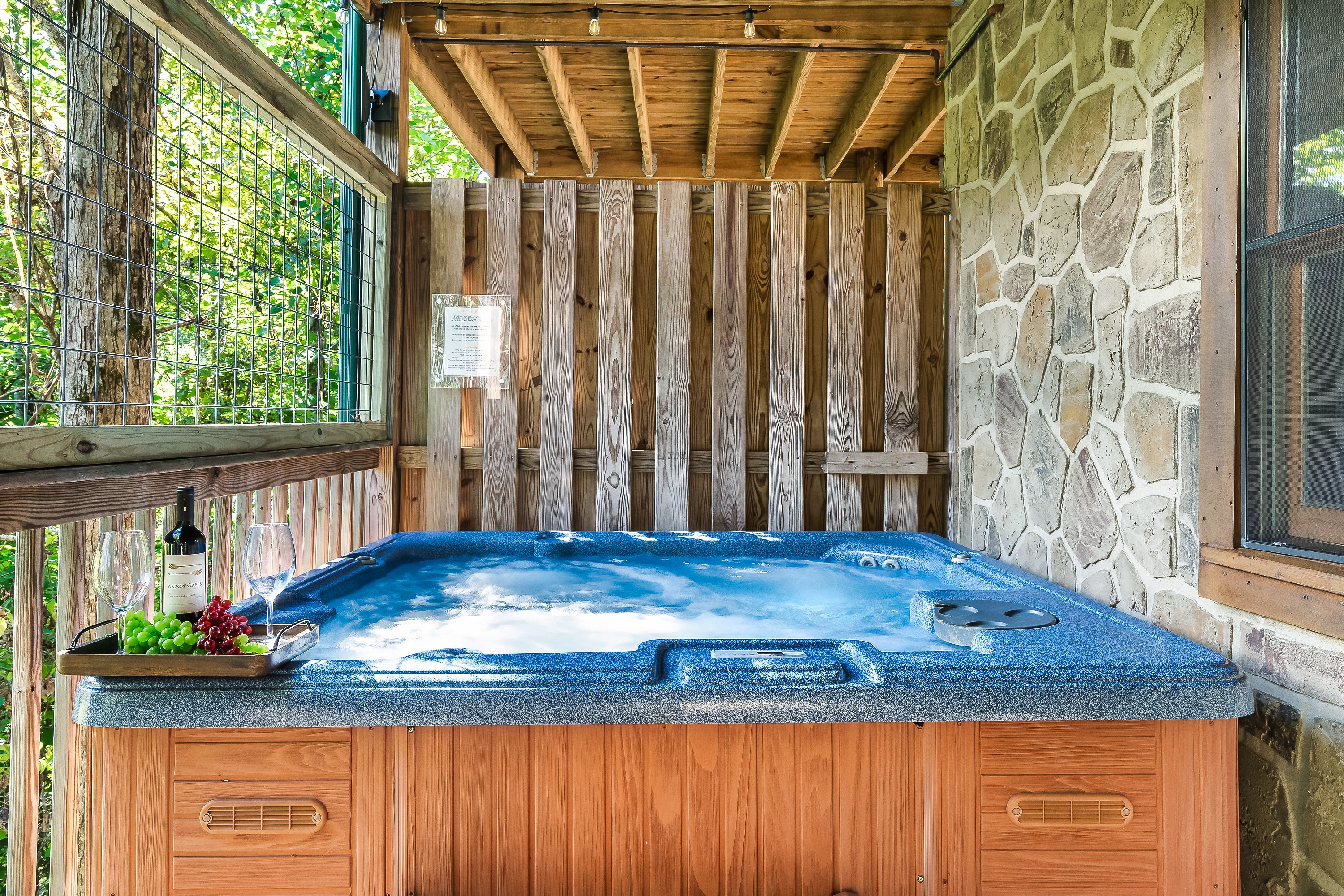 Private hot tub on lower level deck with wooded view. 