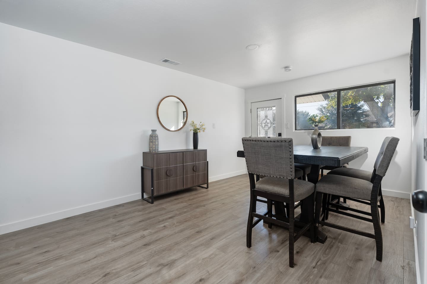 Central dining area with a clean, welcoming design. Located between the kitchen and living room to keep everyone together during your stay.