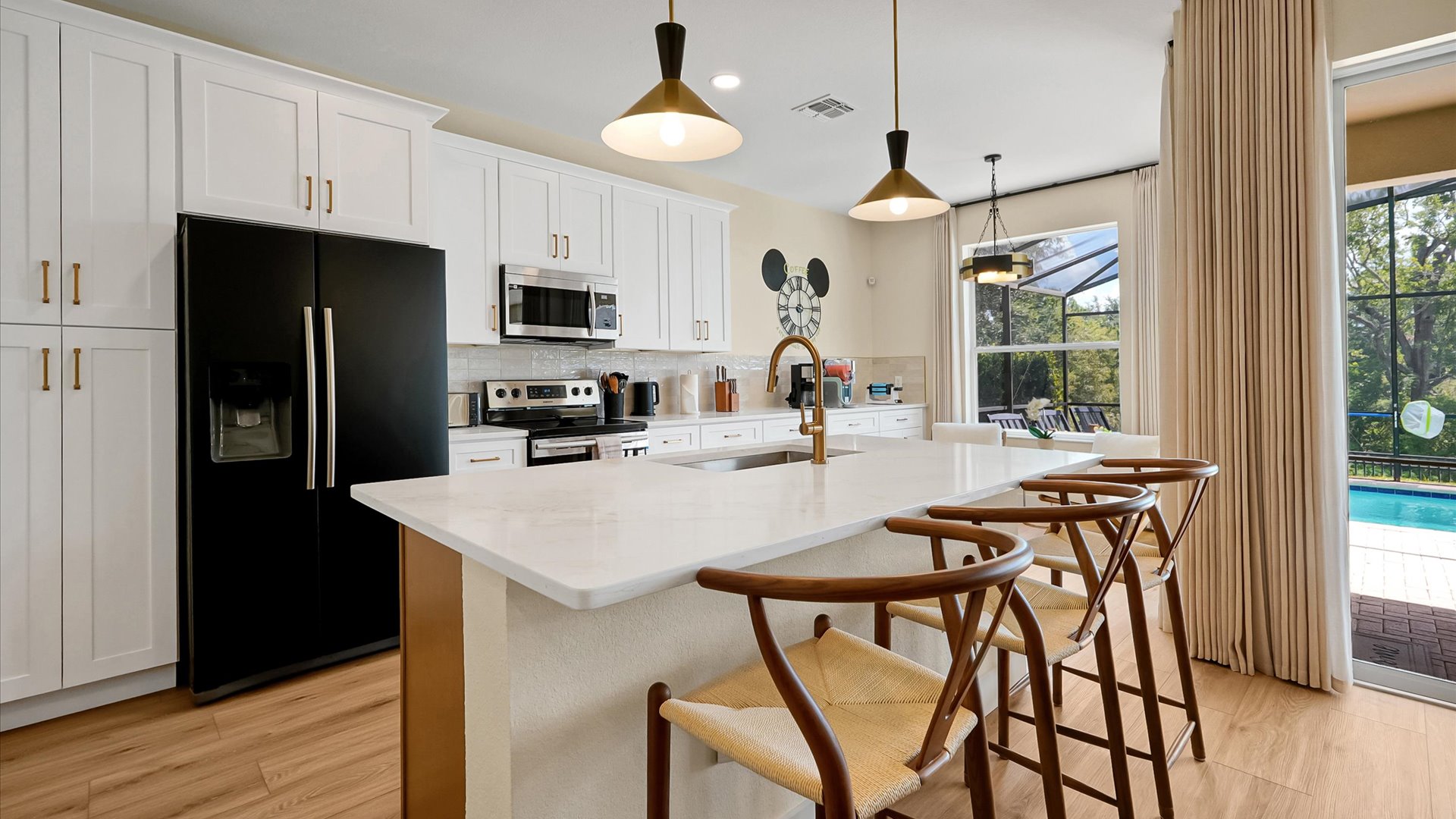 Kitchen: Fully renovated kitchen with island, seating for three and direct access to the private pool area.