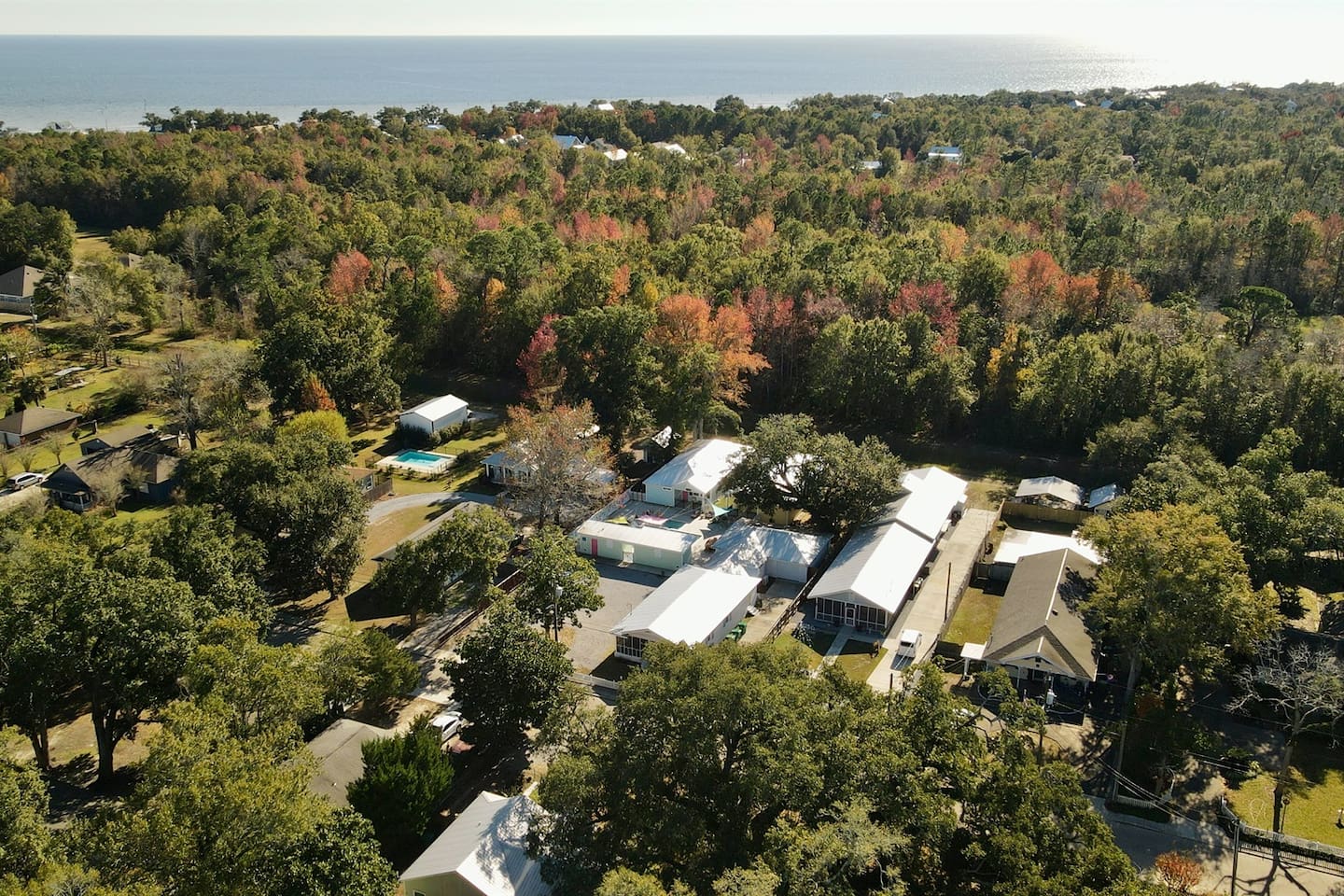 Scenic aerial view showcasing the property nestled among trees, just minutes from the coastline.