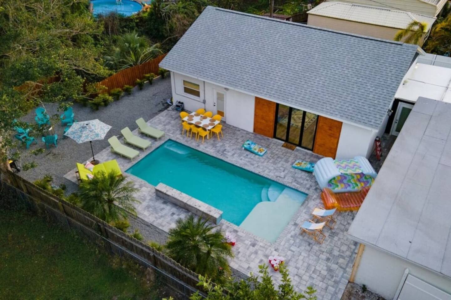 Ariel view of the back part of the house and tropically landscaped pool and patio. 