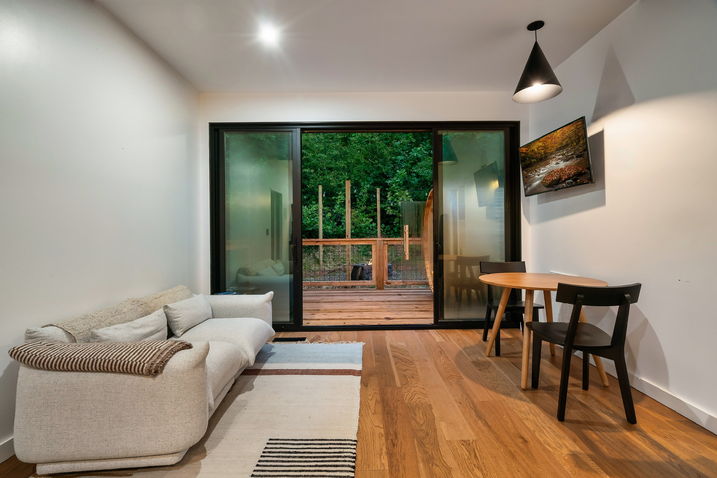 Main living area and dining area! TV on wall and sauna on deck outside.