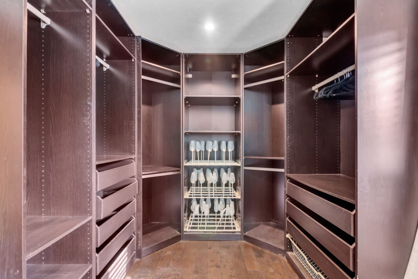 Primary walk-in closet with hangers and ample open storage space for easy unpacking and longer stays.