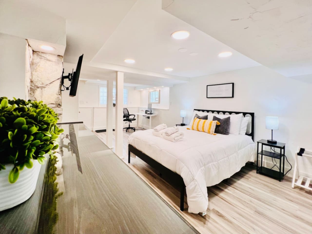 Spacious queen-sized bedroom with a dedicated working space and a TV, offering the perfect blend of comfort, productivity, and entertainment.