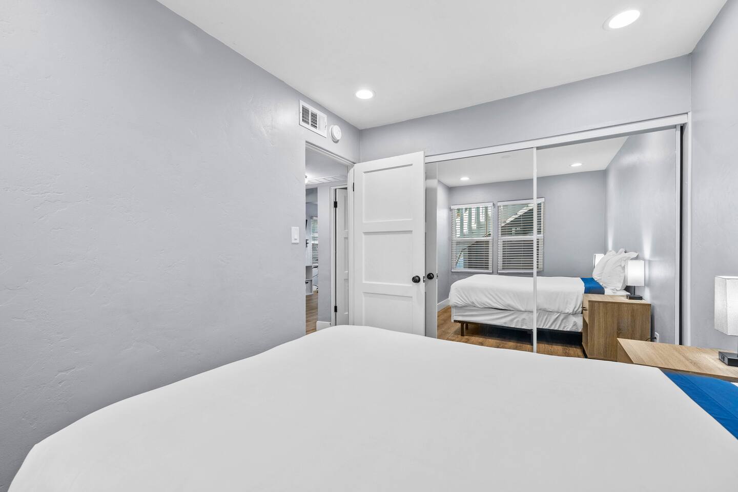 Relax in our cozy bedroom featuring a stylish mirror, creating a bright and inviting space. Perfect for a restful night’s sleep and a refreshing start to your day!