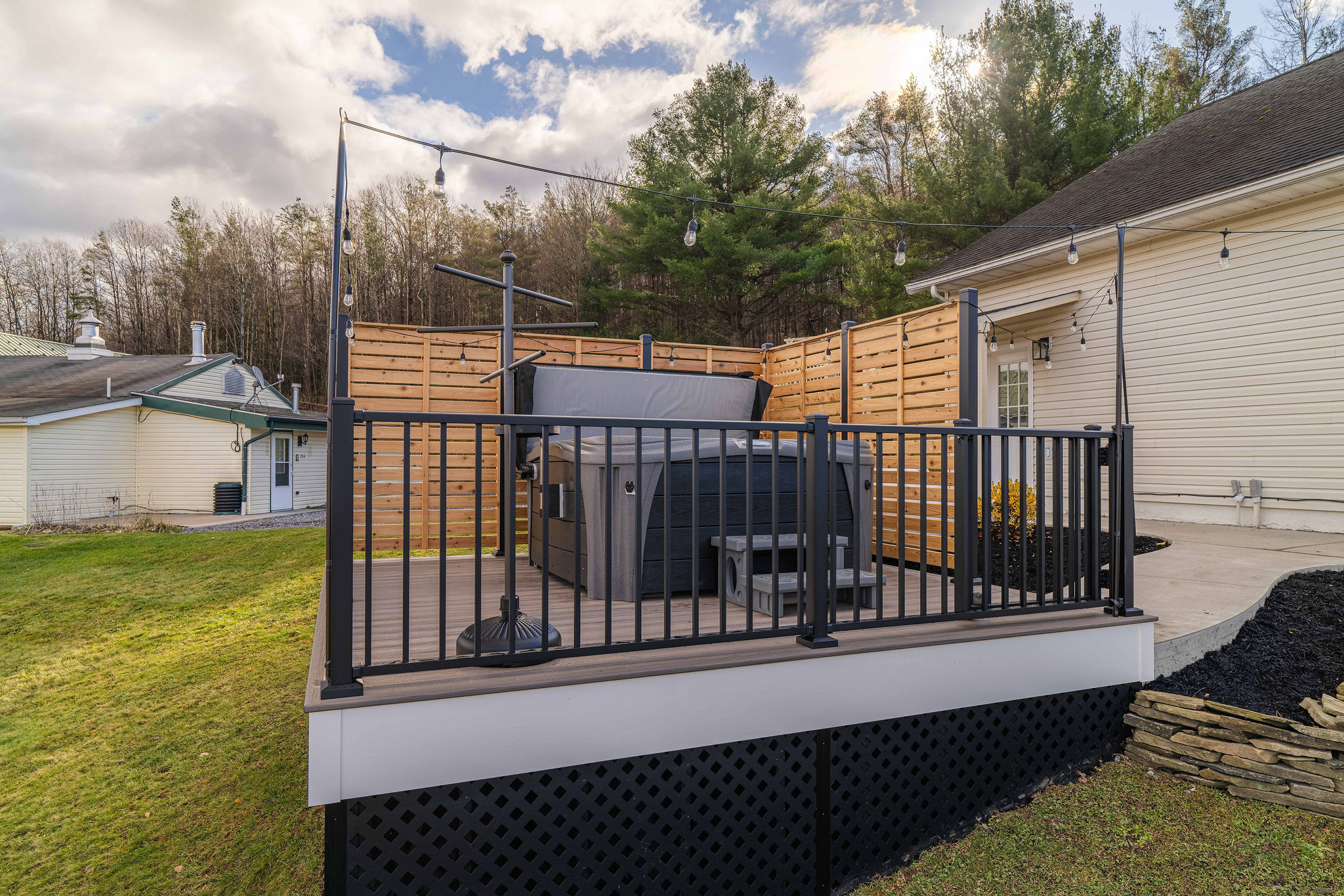 Private 5-Person Hot Tub with Mountain Views. Relax in total comfort with privacy walls, string lights, and peaceful hilltop scenery.