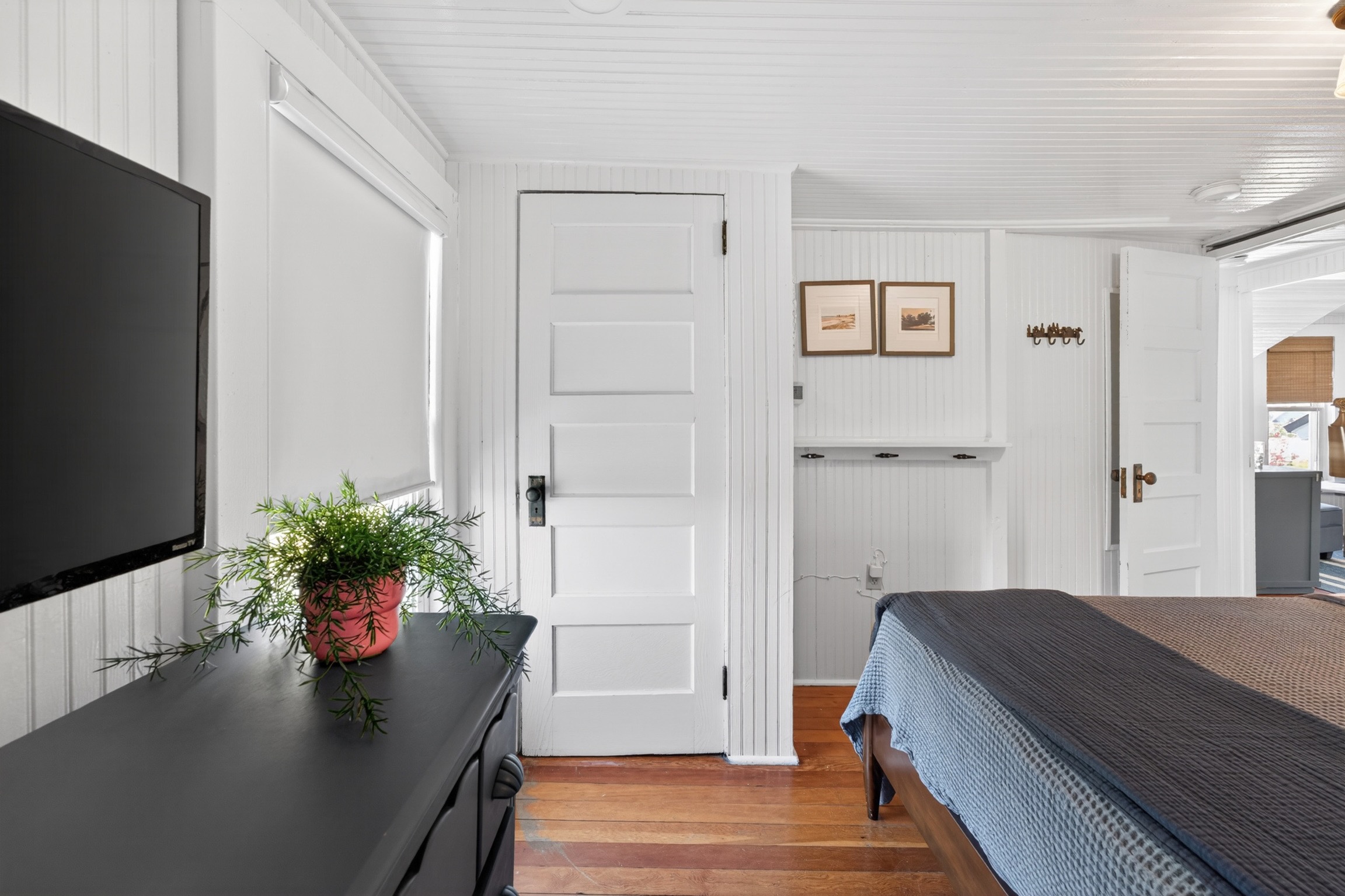 Master bedroom featuring a king bed, smart TV, dresser and closet space.