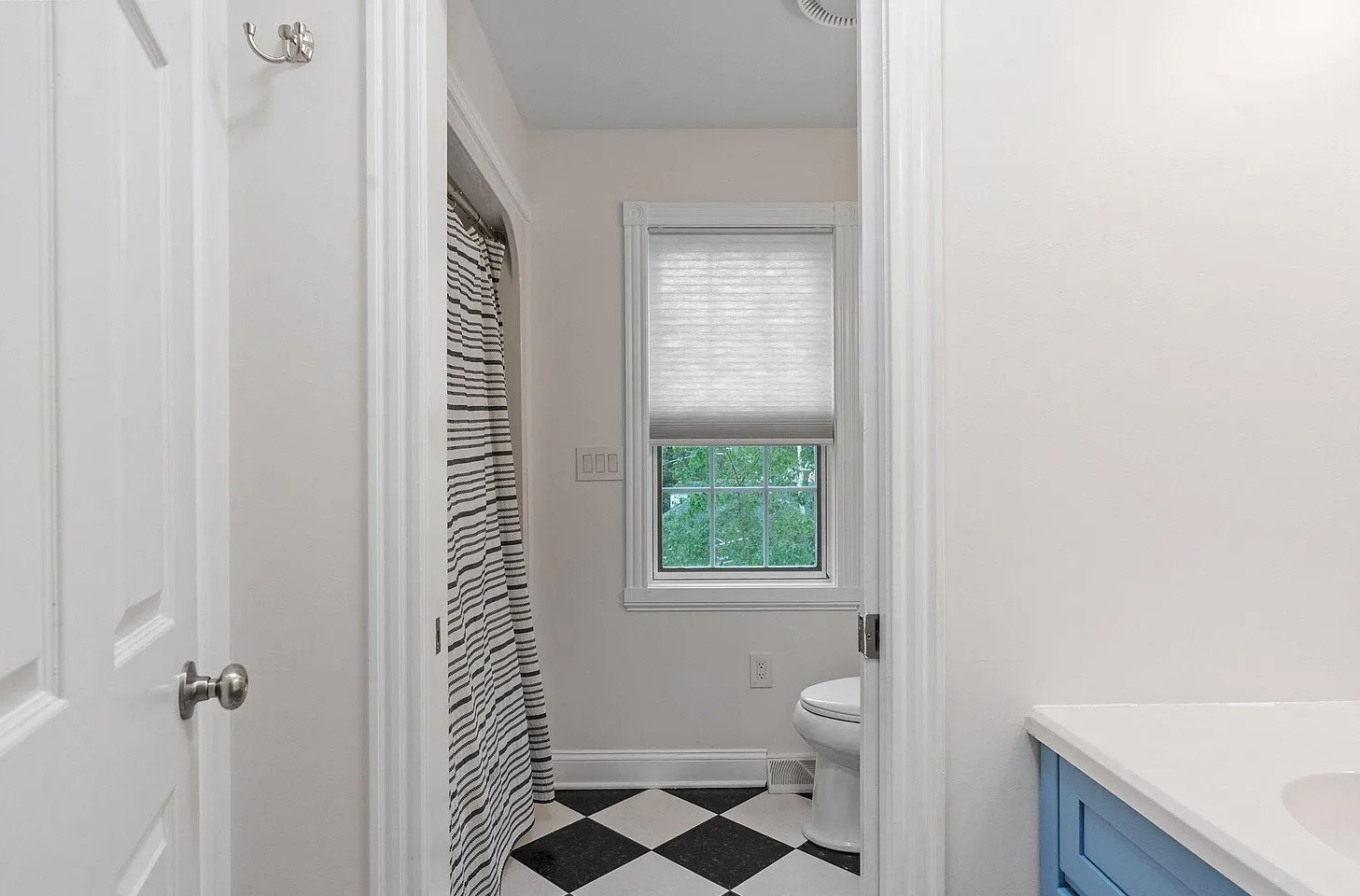 Designed for convenience, the upstairs shared bath features a separate vanity area with sink and mirror for getting ready, leading into a private bath space with a second sink, toilet, and shower.