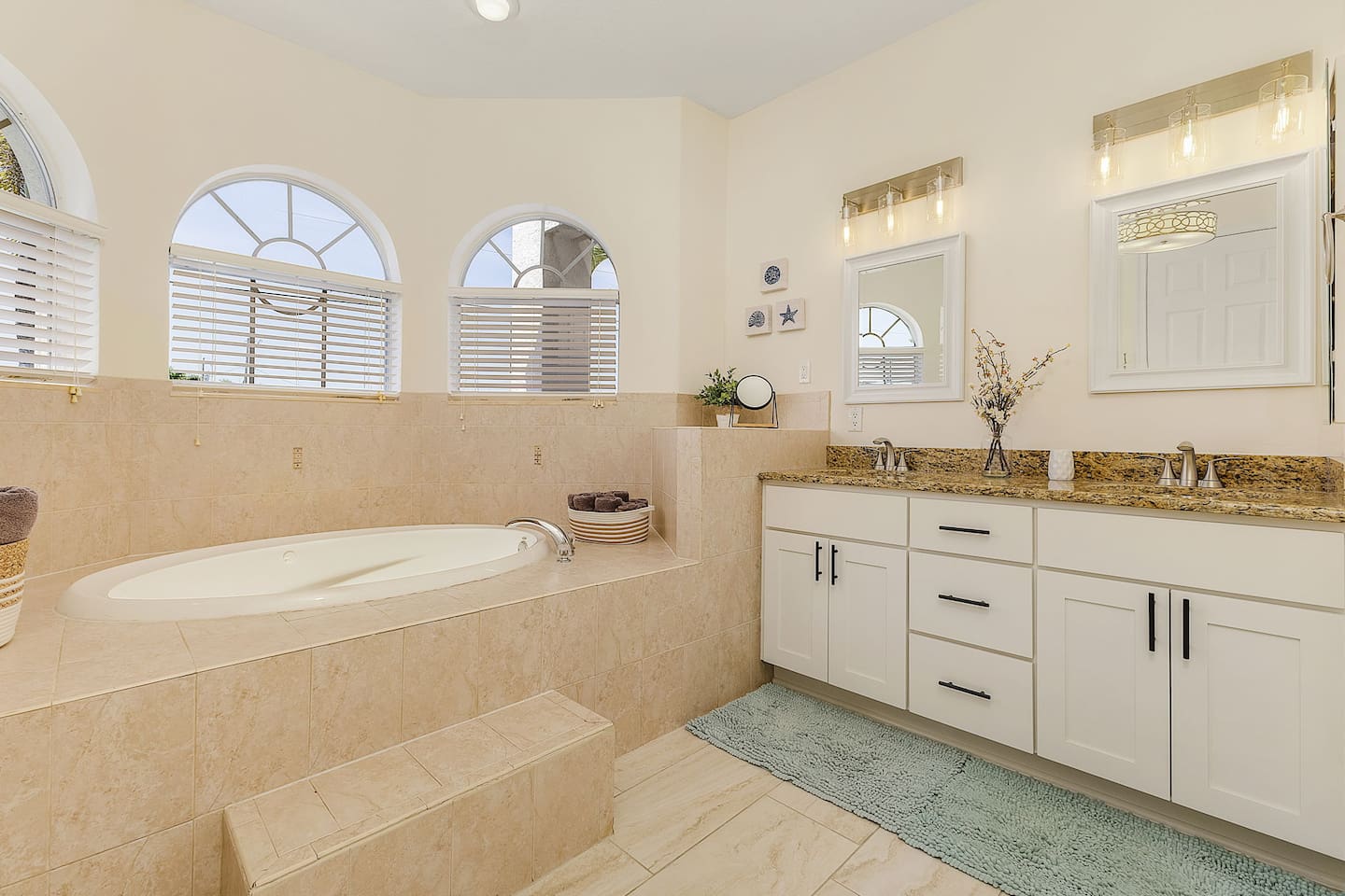 Primary ensuite bathroom with dual sink and a relaxing tub.