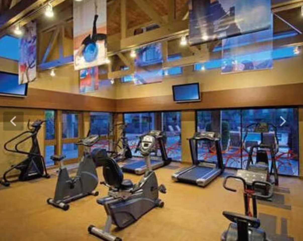A full community fitness studio with cardio machines overlooking the courtyard — no excuse to skip your workout on vacation.