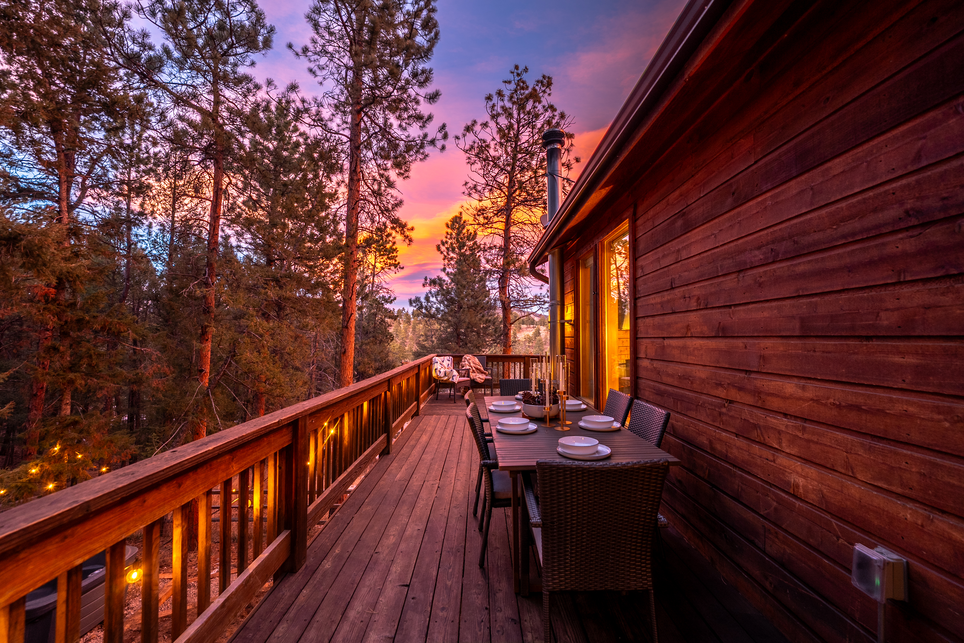 🍽️🌅 Dine on the deck at sunset—string lights ✨, warm cabin glow, and pine-filled views that turn every meal into a moment 🌲🥂