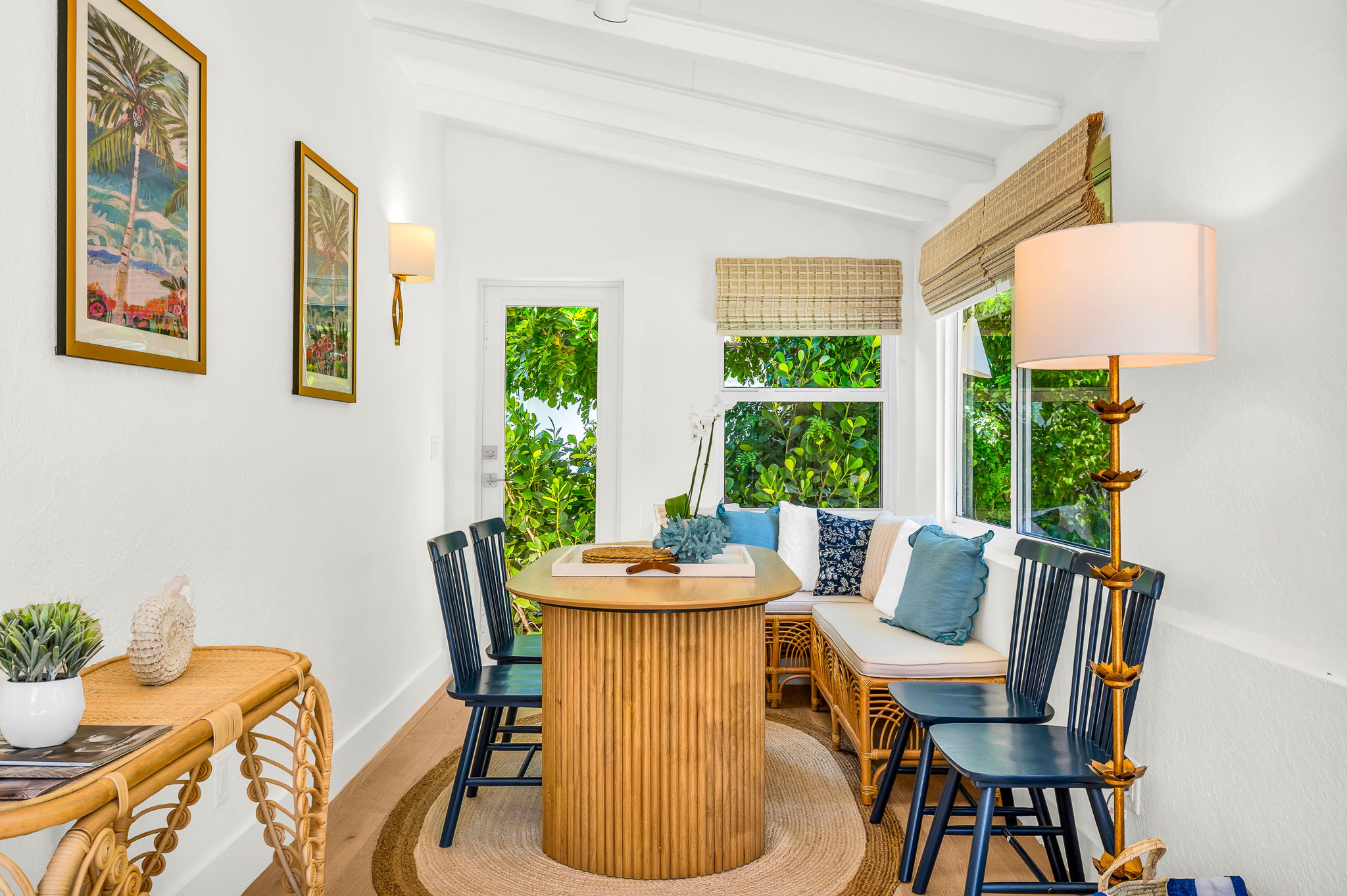 Sun-drenched sophistication—this inviting Florida room features seating for six, a chic bar cart, and panoramic pool views framed by bamboo woven shades. Perfect for intimate meals, morning coffee, or evening cocktails with a tropical backdrop.