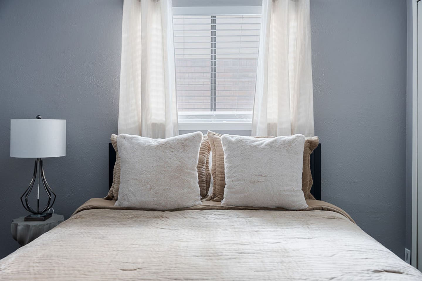 Find serenity in this beautiful bedroom featuring natural light, a comfy double bed, a nightstand and a lamp for your relaxation