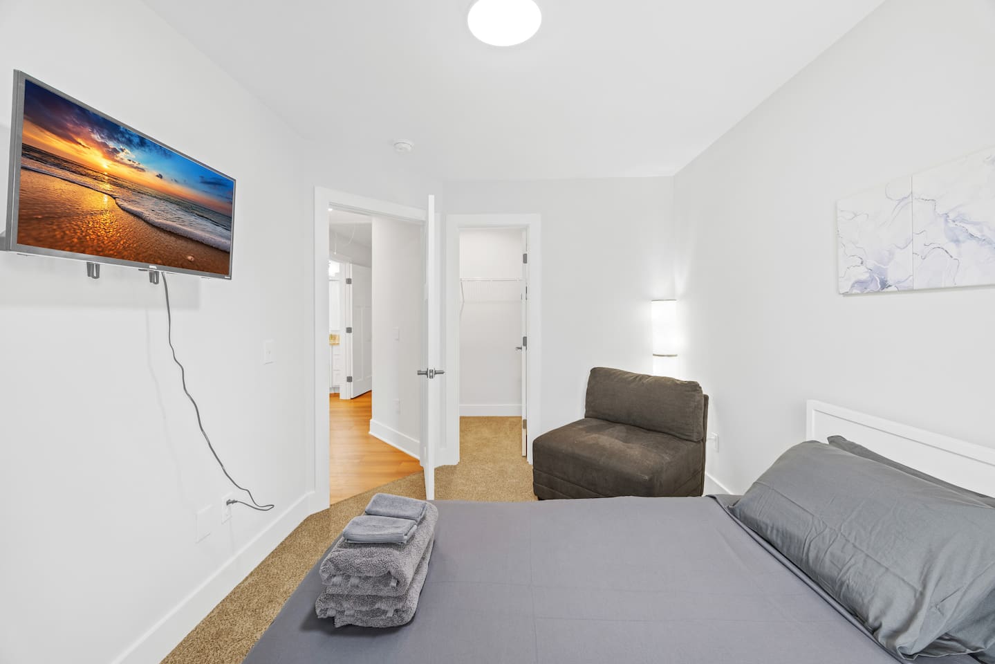 Enjoy your favorite shows on the wall-mounted TV, with easy access to a walk-in closet and plenty of natural light from the large window.