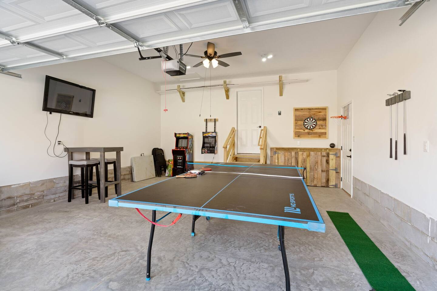 entertainment garage. featuring ping pong, putt putt, darts, tv, arcade games, basketball. Also outdoor games such as cornhole boards, chipping game, etc.