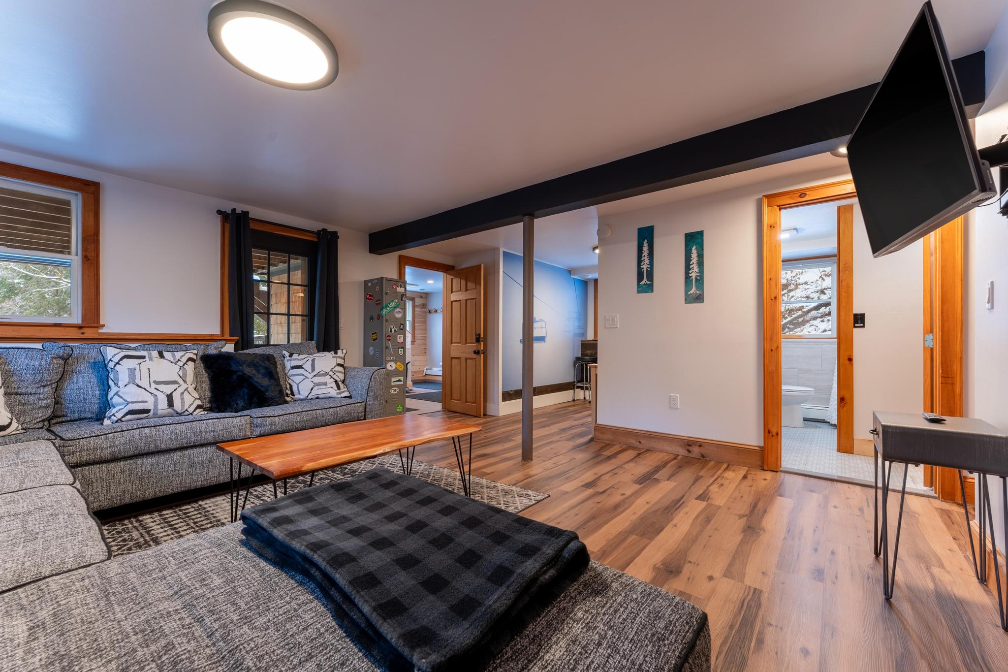 1st floor living room with arcades, TV, & full bath