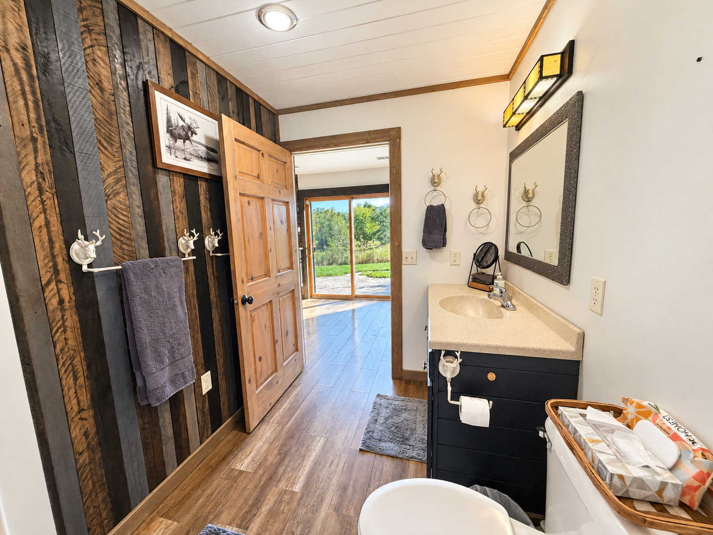 Looking out from the bathroom, you’ll see the patio doors and the path toward the stairs. Head up to the third level, where you’ll find three additional bedrooms and a full bathroom.