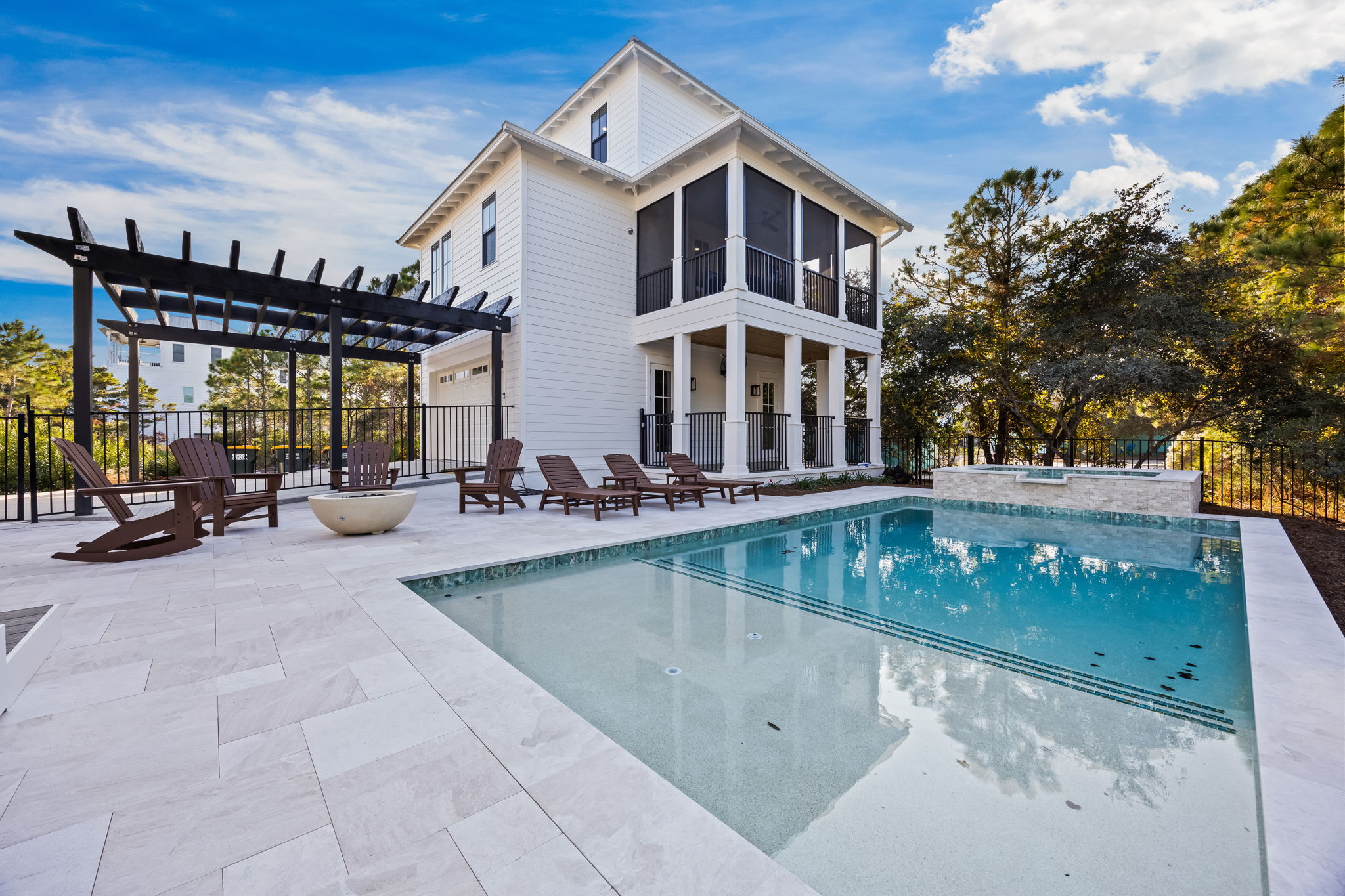 Private pool, spa, and patio oasis with Guest House views—featuring fire pit seating, multiple porches, and seamless indoor-outdoor coastal living.