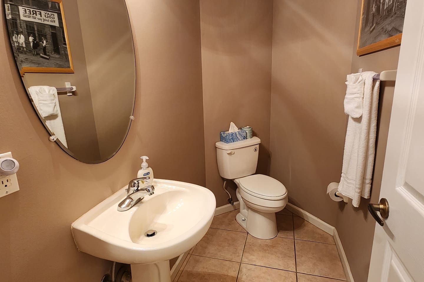 Convenient half bathroom with pedestal sink, tile flooring, and neutral decor.