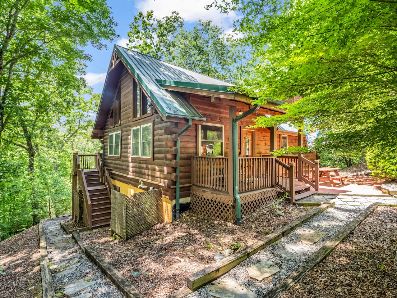 Front and side view of the cabin surrounded by mature trees
