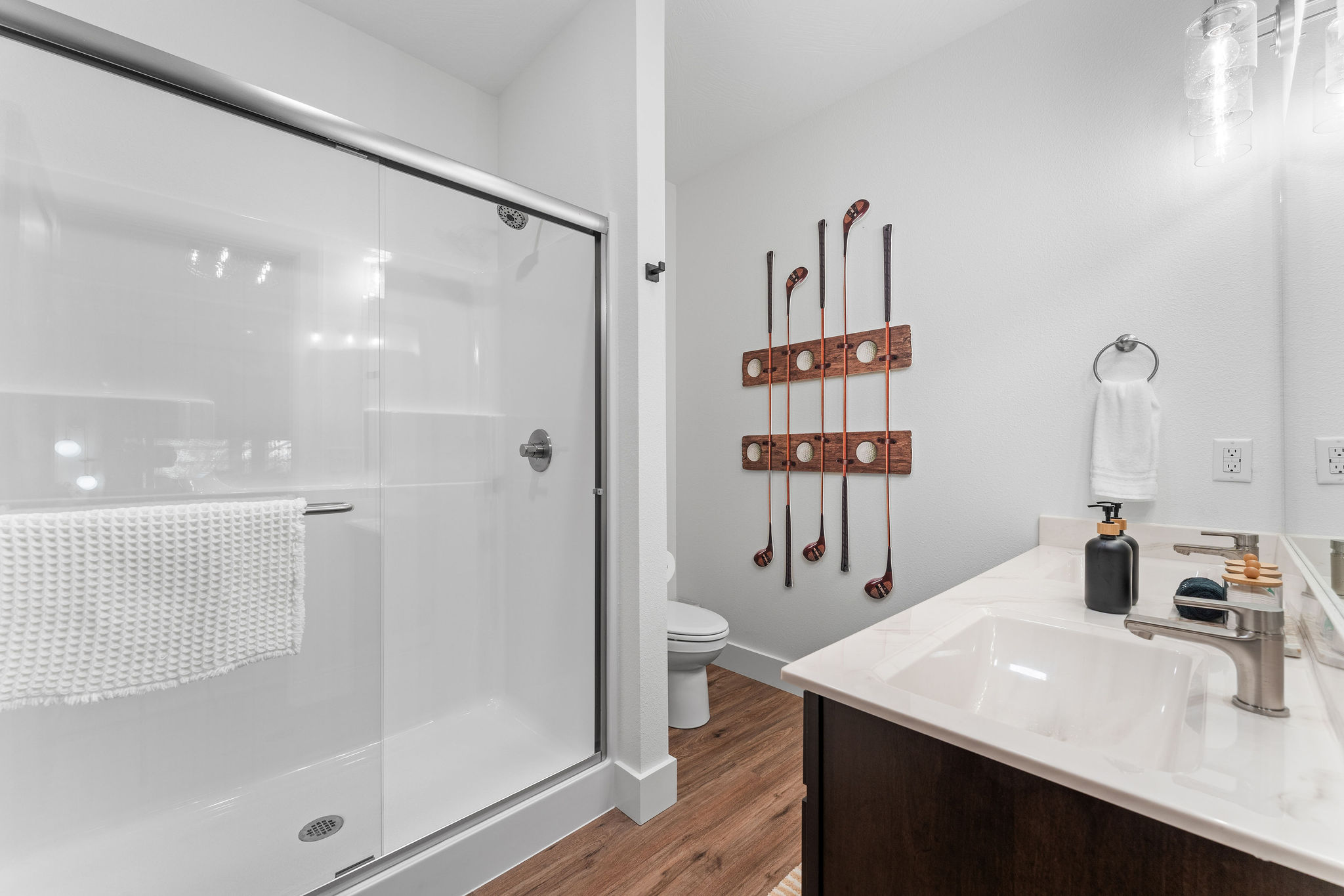 The Par and Pine Golf bathroom has a walk-in shower and some cool custom artwork.