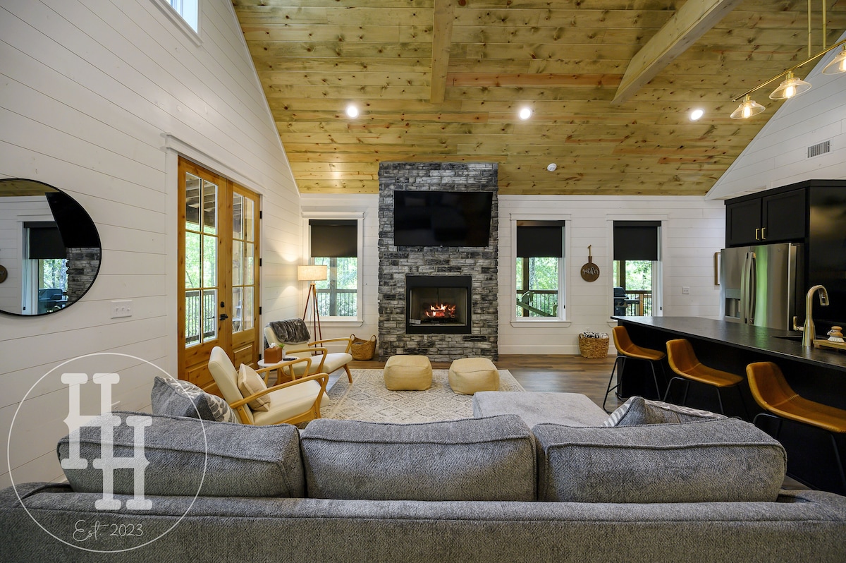 Living area with couch, designer chairs, gas fireplace, and smart TV.