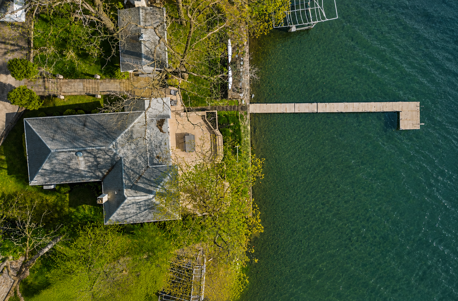 Aerial view of the property showcasing its lakeside location and private dock. Perfect for water activities, relaxing by the lake, and enjoying the natural beauty. An ideal retreat for outdoor enthusiasts!
