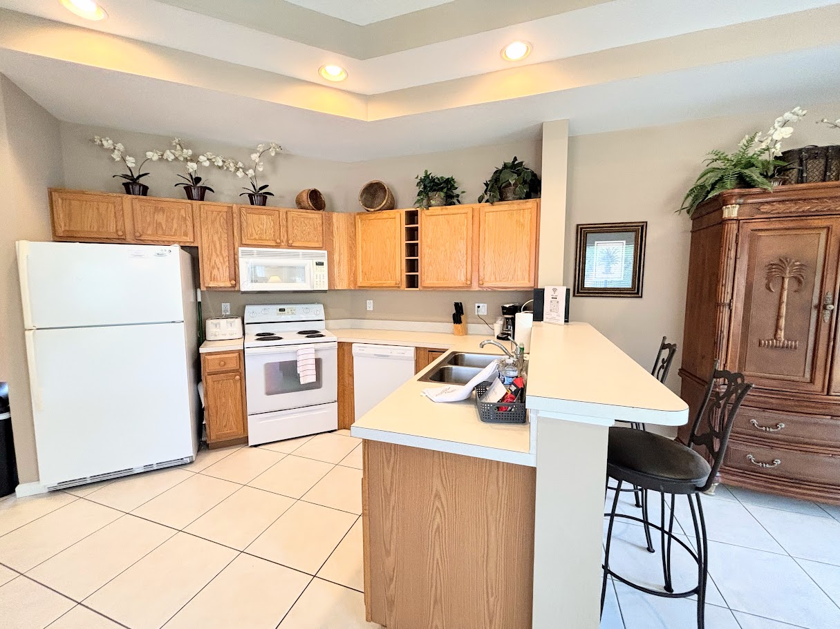 Spacious kitchen with plenty of cabinet storage, full-size appliances, a breakfast bar, and an open layout that flows into the dining and living areas.