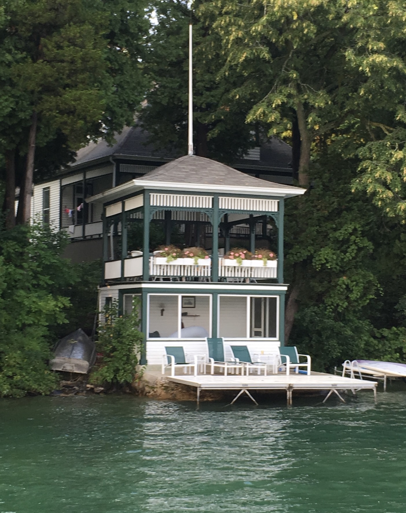 Screened lakeside porch w/ dining table for breezy outdoor meals