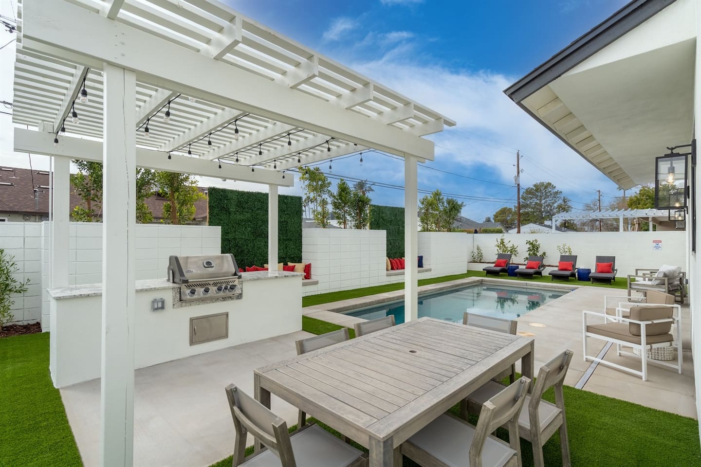 Experience outdoor dining at its finest with a stylish pergola featuring a grill and preparation area, paired with a cozy dining space for delightful gatherings under the stars.
