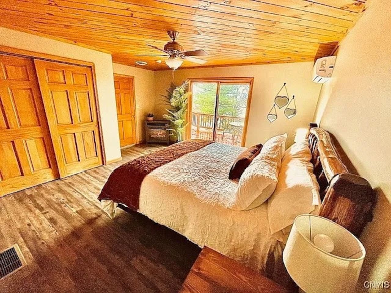 This bedroom features a lake view, king size adjustable bed, electric fireplace, en suite bathroom, and sliding glass door onto the balcony.