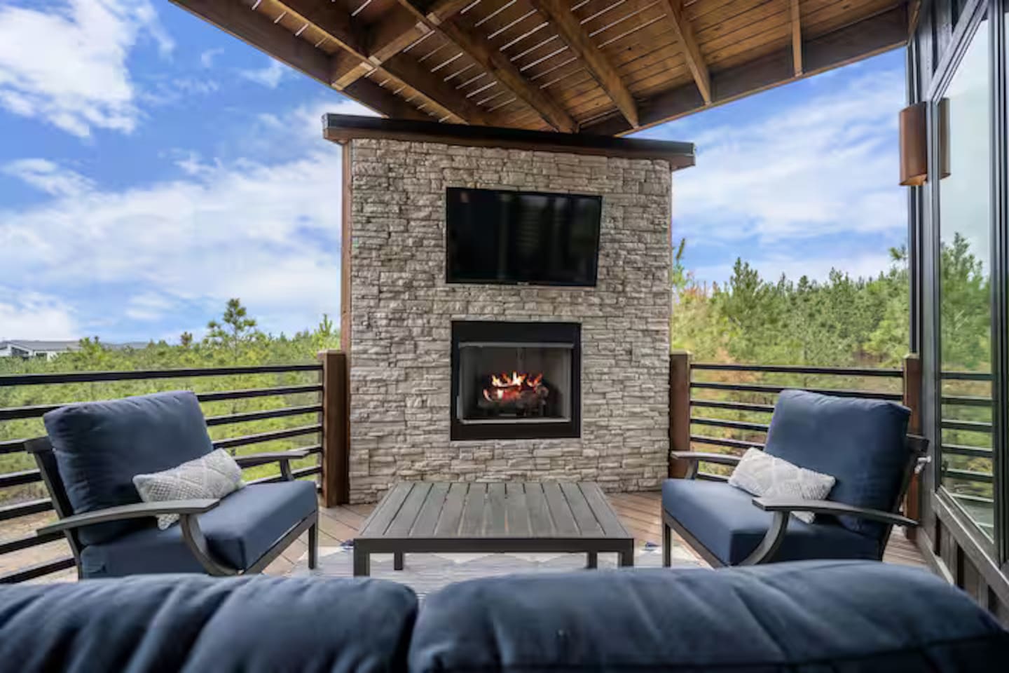 Covered outdoor patio with fireplace and comfortable seating.
