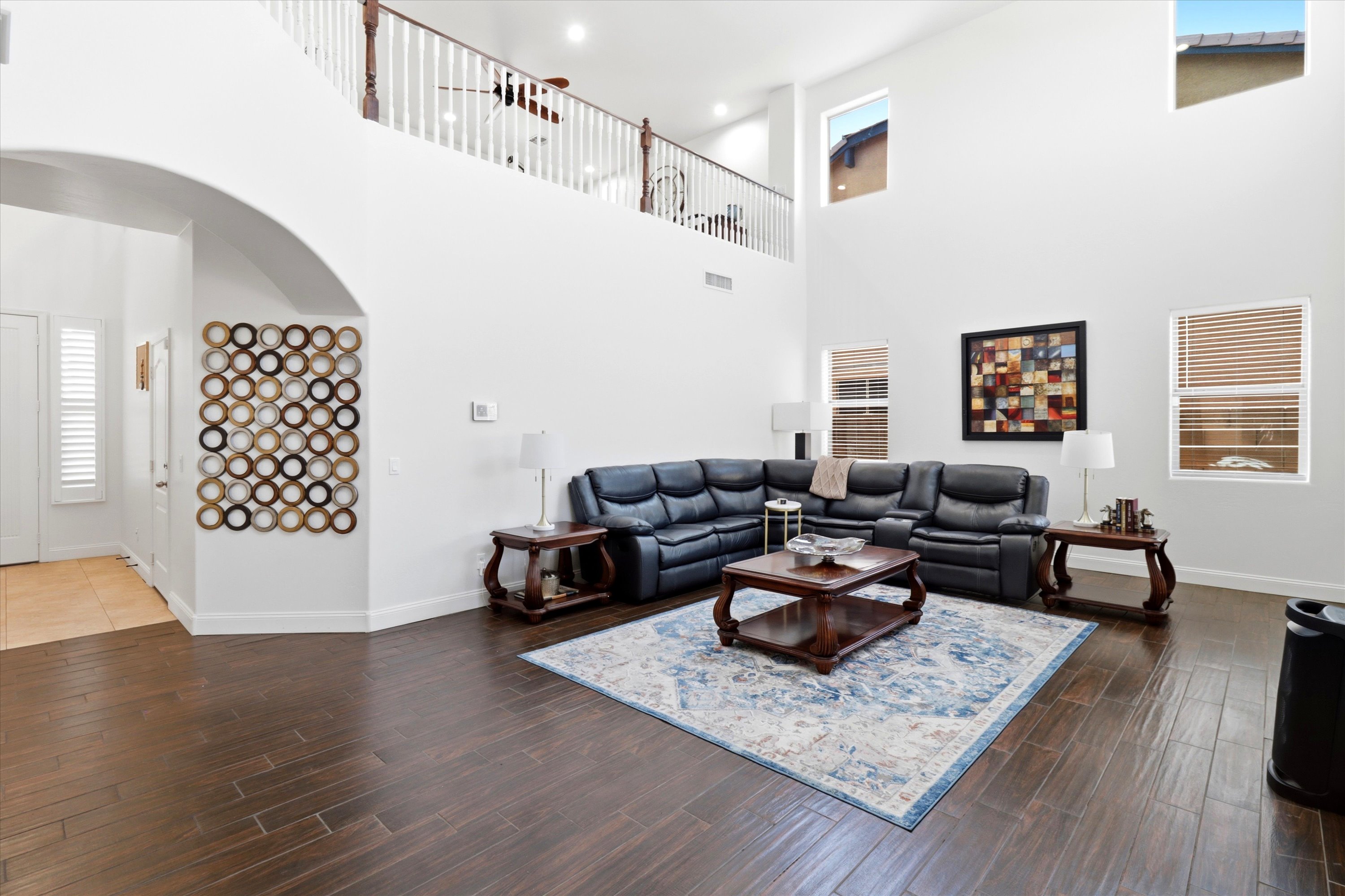 Living room with high ceilings, leather seating, and plenty of space to relax together.
