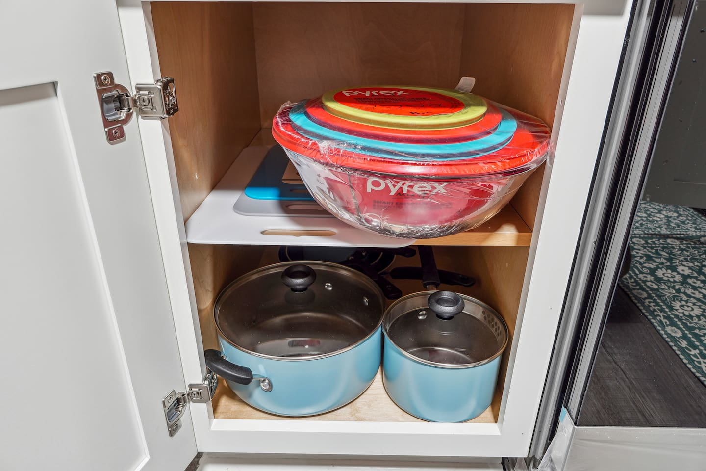 A fully equipped kitchen with a refrigerator, microwave, stove, oven,fridge, dishwasher, coffee maker, kettle, toaster, and blender. Includes plates, bowls, utensils, pots, and pans, plus four bar chairs for casual dining or socializing.
