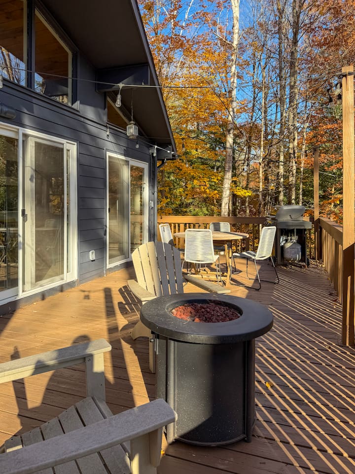 Upper deck with a grill, fire pit, and dining area, accessible from the living room