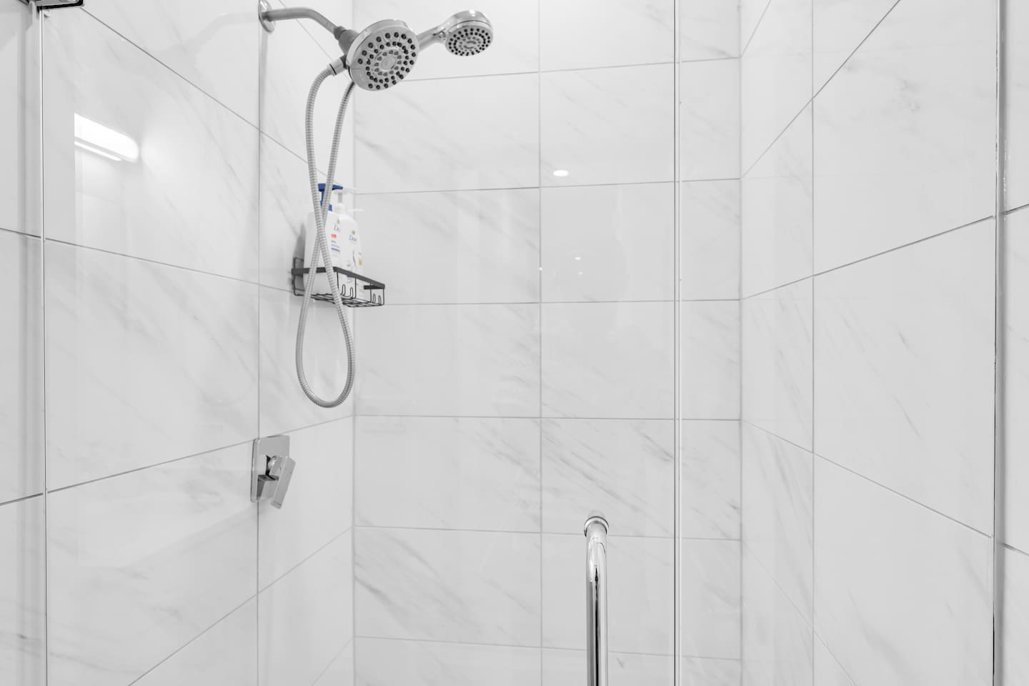 Enjoy a relaxing rinse in the modern tiled walk-in shower with premium bath products provided.