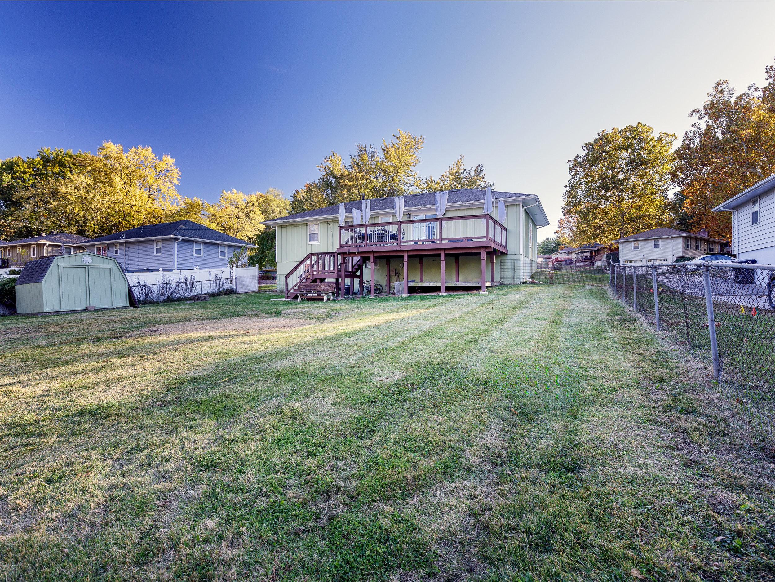Open backyard view with green space behind the home, ideal for outdoor enjoyment.