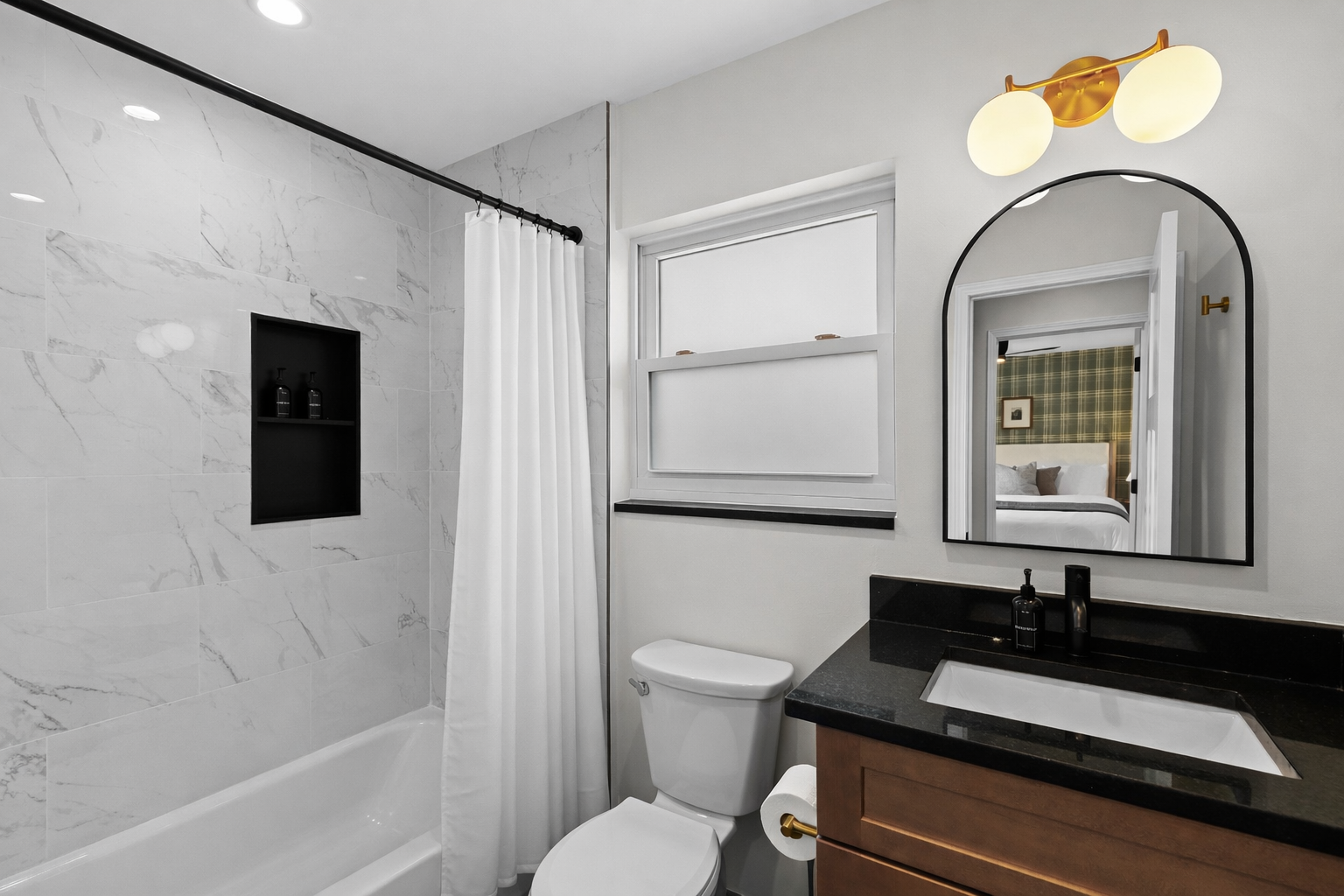 Modern bathroom with a tiled tub shower, sleek vanity, and bright lighting—clean, stylish, and thoughtfully designed for everyday comfort.