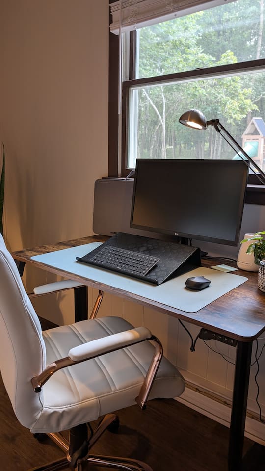 The work-cation setup - 24" LED monitor (with HDMI cable), Bluetooth keyboard and mouse, an adjustable standing desk, and a super comfy, stylish chair. Plus, a portable laptop desk means you can take your replies to the backyard or Adirondack chair.