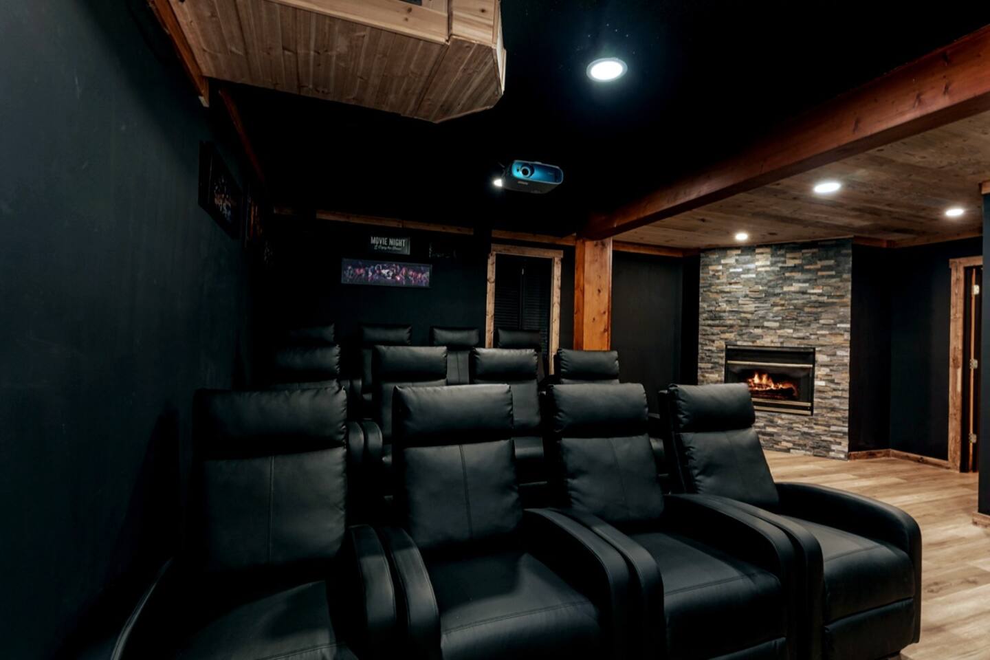 The home theater room has an extra seating area around Stone  Fire Place. 
