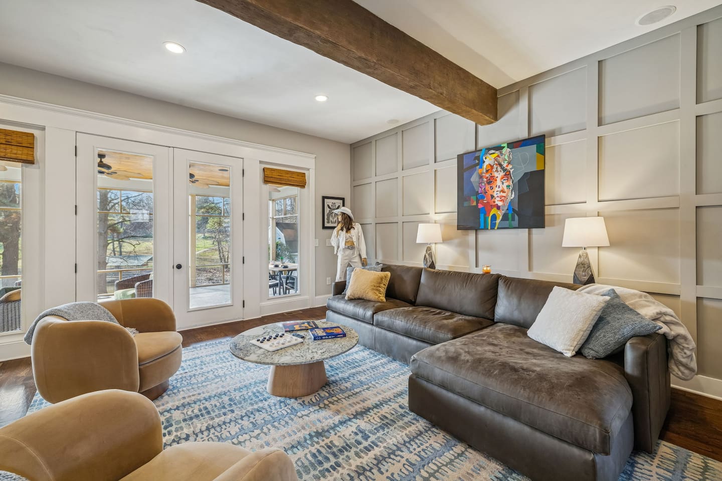 Upscale furnished Living Room with a leather chaise sofa with views of the lake, kitchen and 65" TV over the fire place